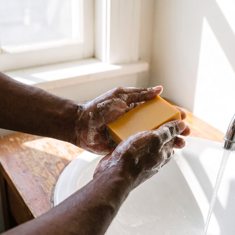 Washing hands with Turmeric soap bar under running water, smooth finish, lifestyle photo